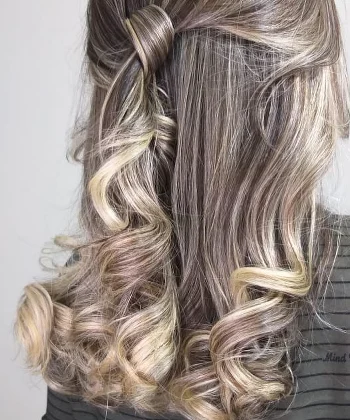 Penteado meio preso com cachos modelados e mechas claras