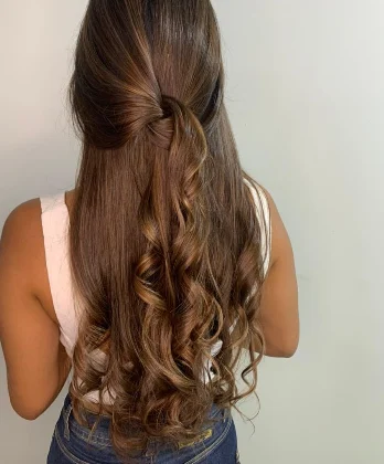 Castanho iluminado com cachos e penteado meio preso